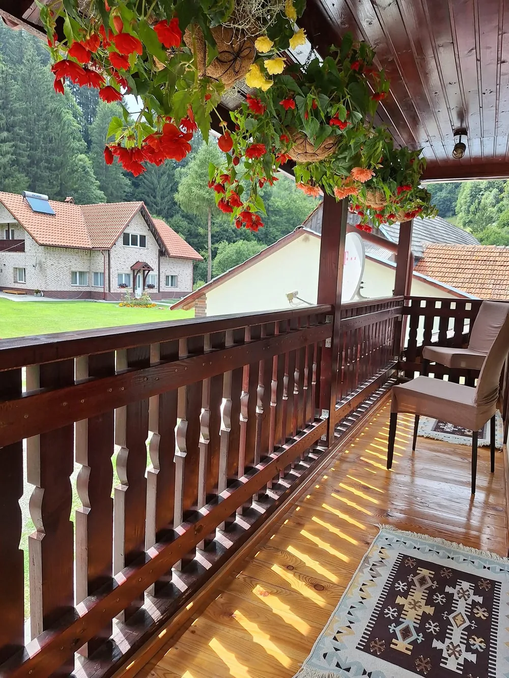 Scaune pe pridvorul de lemn, printre ghivece cu flori