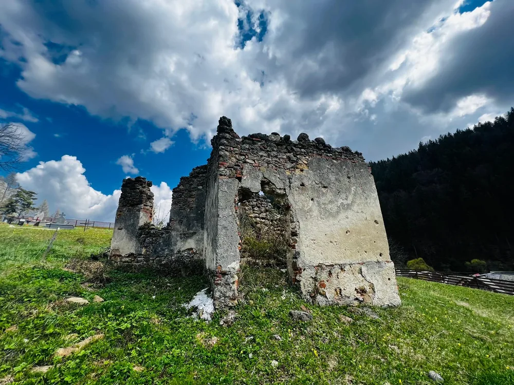 Ruinele fostei capele, în poiana din fața căsuței
