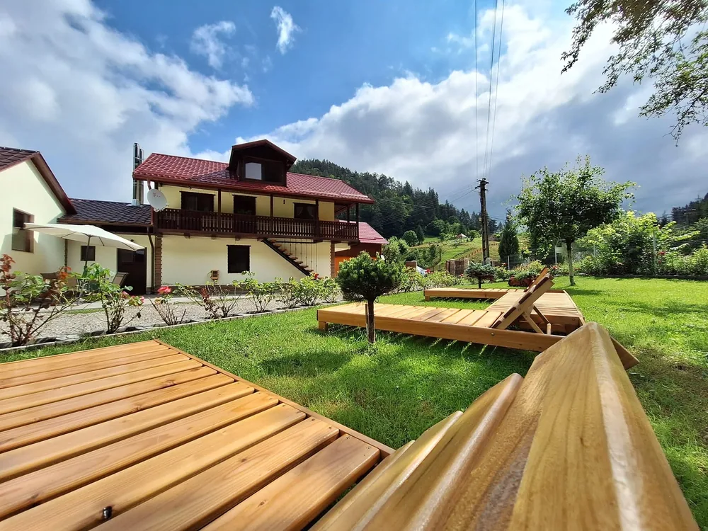 Șezlonguri din lemn în grădina verde a Căsuței cu Pridvor